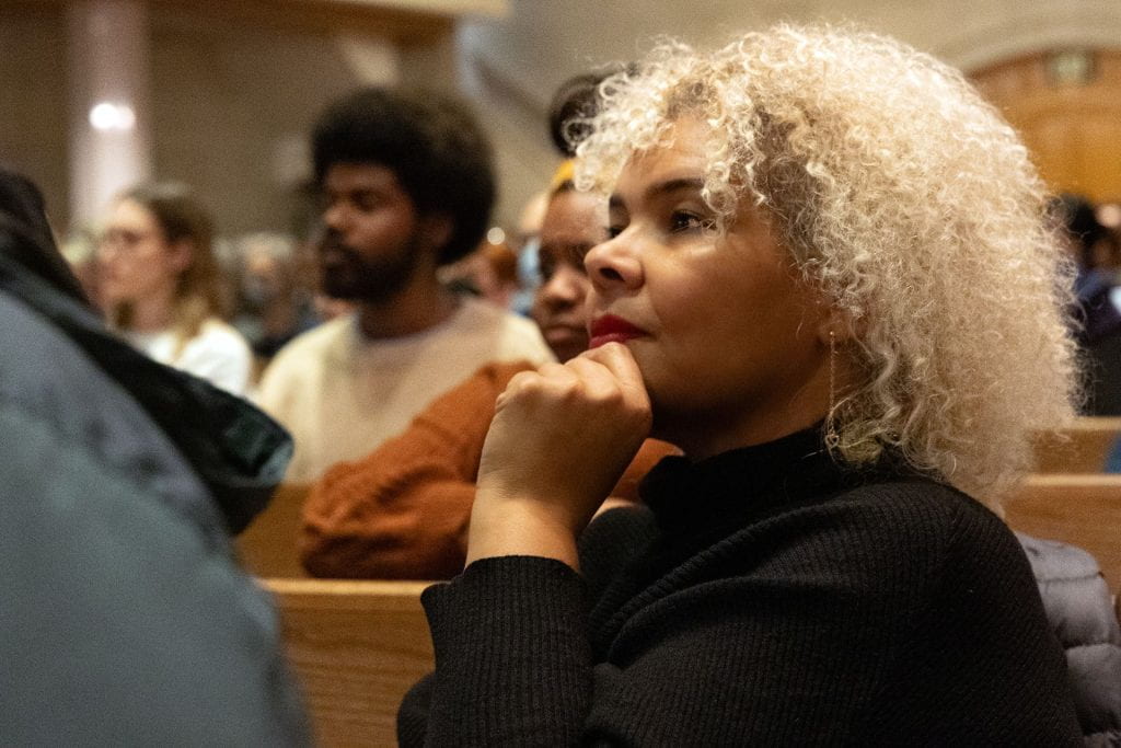 Member of the audience listens as Heather McGhee delivers a talk on "The Sum of Us: How Racism Hurts Everyone" on stage at Graham Chapel